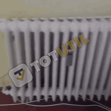 Calorifer vechi de fontă sub geam, într-un apartament de bloc
