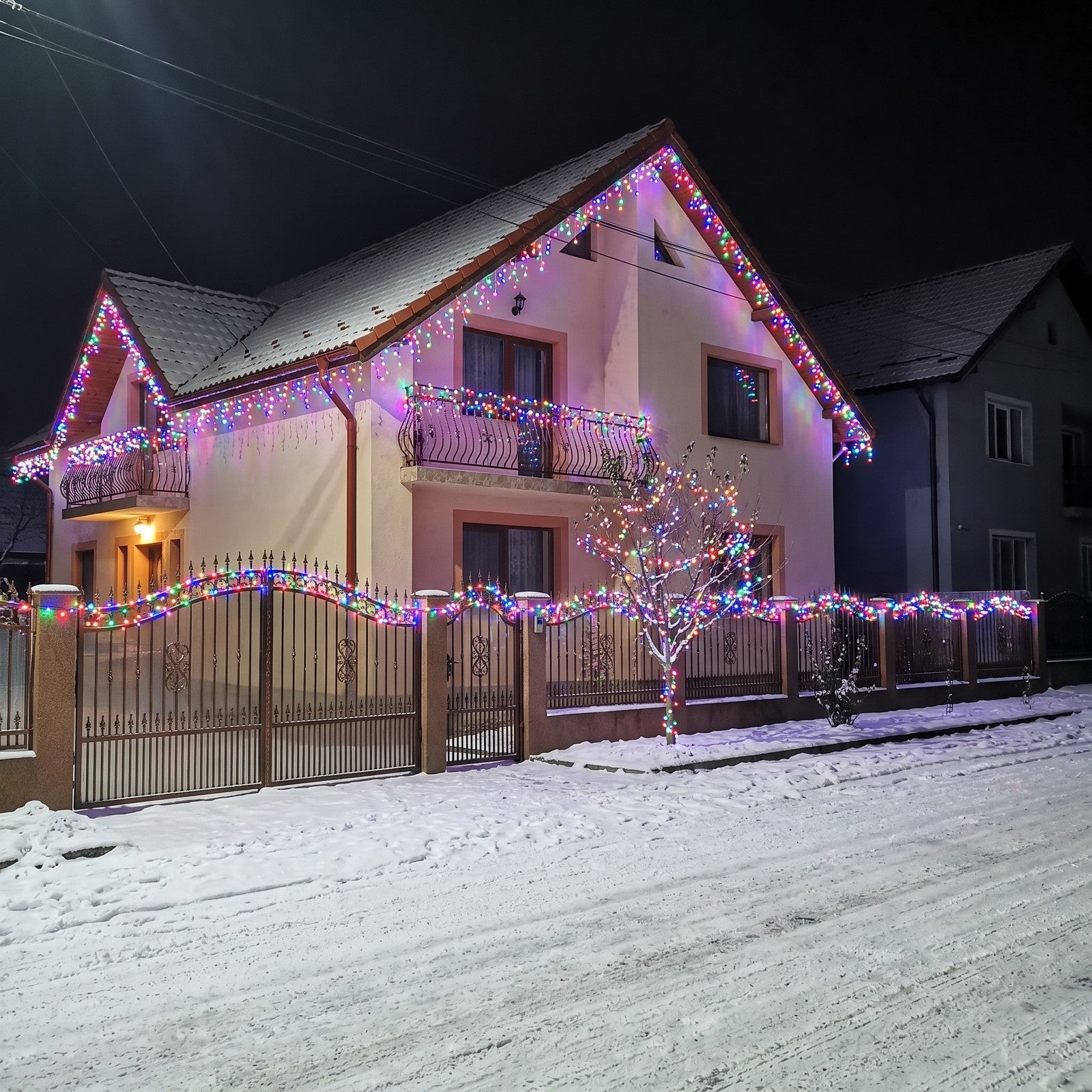 streașina, balconul și gardul casei luminate de instalație