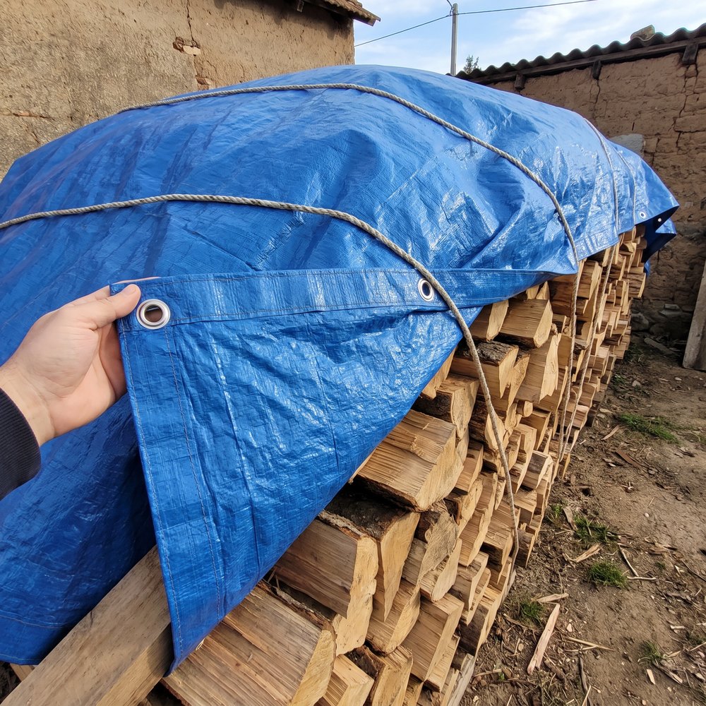 prelata trasă peste stiva de lemne