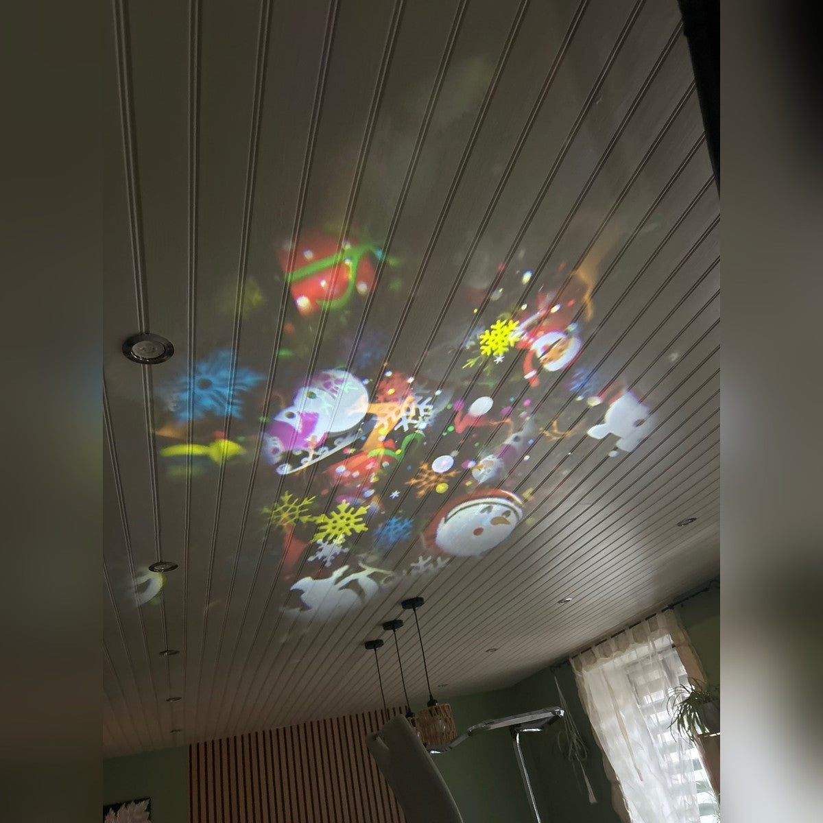 Moși, oameni de zăpadă și fulgi proiectați pe tavanul sufrageriei